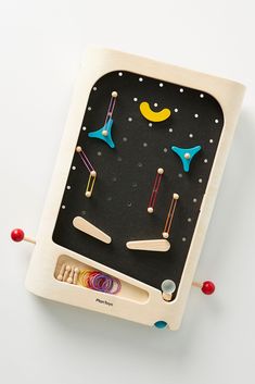 a wooden toy with different colored objects on it's sides and an object in the middle that looks like a board game