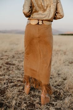 This fringed, flowing skirt pays tribute to Lily’s ties to Nevada. With a touch of Western elegance, it captures the beauty of the landscapes that inspired it. Perfect for cowgirls who blend heritage with high fashion, this skirt moves with you, just like the wind over the Nevada sagebrush. True to Size Little to Medium Stretch Faux Suede Fringe Detailing Ankle Length Skirt Fall Bohemian Brown Skirt, Bohemian Brown Skirt For Fall, Fitted Bohemian Maxi Skirt For Fall, Fall Festival Fringe Skirt, Bohemian Brown Bottoms With Fringe, Bohemian Lined Maxi Skirt For Fall, Bohemian Brown Fringe Bottoms, Chic Fringe Skirt For Fall, Bohemian Midi Skirt For Fall