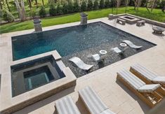 an outdoor swimming pool with lounge chairs around it