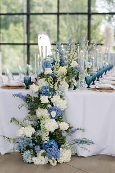 the table is set with blue and white flowers