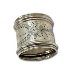 a silver ring with floral designs on the outside and inside, is shown against a white background