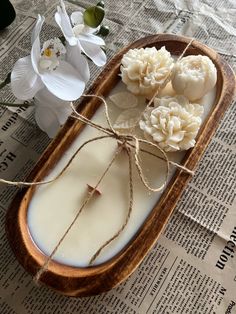 some white flowers are sitting in a wooden bowl