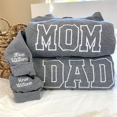 two personalized gray towels on top of each other with the words mom and dad printed on them