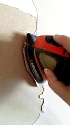 a person using a sanding machine on a piece of paper that has been torn off