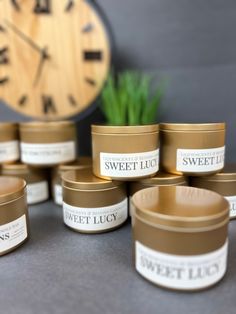 several candles sitting next to each other on a table with a clock in the background