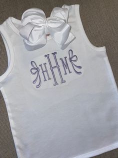 This cutesy tank top is precious for your girls! It features an adorable embroidered bow on either side of monogram. If there is a specific size/color you were hoping to see, msg me to discuss. Fitted Sleeveless Tank Top With Bow, White Bow Tank Top For Summer, White Sleeveless Tank Top With Bow, Fitted Cotton Tops With Bow, Fitted Cotton Tops With Bow Detail, Fitted Cotton Top With Bow, Spring Tops With Custom Embroidery, White Bow Tank Top, White Sleeveless Top With Bow