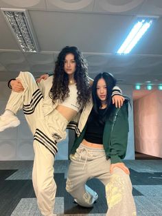 two young women posing for a photo in an empty room with their arms around each other