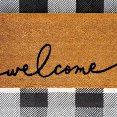 a welcome mat with the word'we come'written in cursive ink