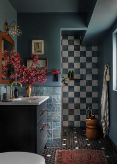 a bathroom with a checkered wall and tiled floor