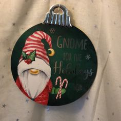 a christmas ornament hanging on a wall with a santa clause hat and candy canes