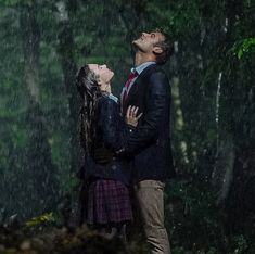 a man and woman standing in the rain