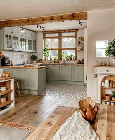 a large kitchen with wooden floors and green cabinets, white walls and wood flooring