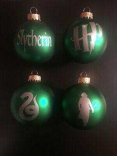 three green christmas ornaments with white lettering on them