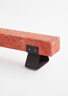 a close up of a bench made out of red bricks and black metal brackets on an isolated white background