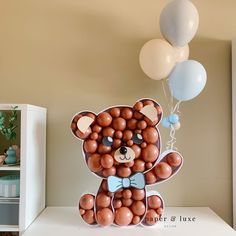 a teddy bear made out of balloons on top of a table