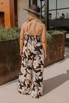 - Kick back and enjoy some vacay vibes in this stylish jumpsuit! - Unlined material with an abstract floral print - A v-cut neckline with a twist detail - Adjustable spaghetti straps - A smocked upper back with a tie detail - A wide legged jumpsuit with floor length hemlines Chic Printed Jumpsuits And Rompers For Vacation, Chic Printed Jumpsuit For Vacation, Chic Floral Print Jumpsuits And Rompers For Beach, Chic Floral Print Beach Jumpsuit, Chic Beach Jumpsuit With Floral Print, Chic Tropical Print Jumpsuits And Rompers For Vacation, Chic Tropical Print Jumpsuit For Vacation, Black Printed Jumpsuits And Rompers For Beach, Black Printed Jumpsuit For Beach