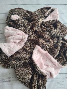 a pile of pink and brown leopard print hair ties on top of a white wooden floor