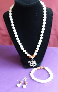 This set is made with 8mm imitation stones, Rudraksha, and clear Rhinstones, Rondelle spacers. It is three pieces set, Necklace with OM pendant, Bracelet with Rudraksha and silver tone Rondelle spacers, and Ear rings. It is a prayer mala for yoga and for protection.Necklace is twenty inches long excluding pendant. OM pendant is one inch in diameter.  The size of the Bracelet is 7 inches to fit a medium size wrist. Earring is made with one Rudraksha and one stone bead. Meditation Beads Mala, Om Pendant, Meditation Beads, Protection Necklace, Set Necklace, Mala Necklace, Ear Rings, A Prayer, Mala Beads