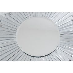 a white circular mirror with clear glass strips on the bottom and center piece in the middle