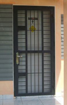 a black door with bars on it in front of a building