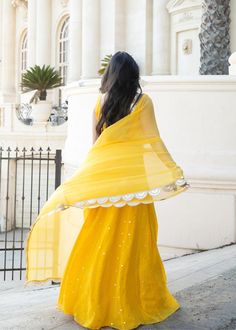 This showstopper mango yellow, Devi, is a must have for your mehendi/haldi ceremony! This colorful and playful mirror lehenga is the perfect party piece. Blouse, skirt, and dupatta included. Yellow Floor-length Sharara With Sheer Dupatta, Summer Wedding Lehenga With Mirror Work, Yellow Salwar Kameez With Mirror Work For Festivals, Festive Yellow Salwar Kameez With Mirror Work, Yellow Chanderi Dress With Mirror Work, Summer Festive Sharara With Dori Work, Yellow Chanderi Salwar Kameez With Mirror Work, Summer Party Lehenga With Sheer Dupatta, Festive Lehenga With Mirror Work For Summer