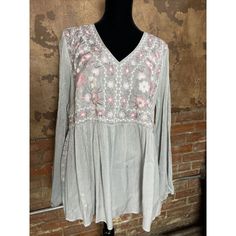 This Beautiful Blouse From Savanna Jane Is A Must-Have For Any Fashion-Forward Woman. The Floral Pattern And Embroidered Accents Make It A Perfect Choice For Any Occasion, From Casual Wear To Business Attire. The Relaxed Fit And Collarless Design Ensure A Comfortable And Stylish Look, While The Pullover Closure Adds A Touch Of Convenience. Made From High-Quality Polyester, This Blouse Is Available In A Plus Size (1x) And Features A V-Neckline And Bell Sleeves. The Gray And Pink Color Combination Spring V-neck Blouse With Chikankari Embroidery, Feminine Embroidered V-neck Blouse, Pink V-neck Top With Floral Embroidery, Flowy Cotton Blouse With Floral Embroidery, Flowy Long Sleeve Blouse With Floral Embroidery, Spring V-neck Chikankari Embroidered Top, Feminine Floral Embroidery Peasant Top, Feminine Spring Tops With Chikankari Embroidery, Floral Embroidered V-neck Peasant Top For Spring