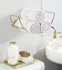 a bathroom with towels and soaps on the shelf next to the toilet, sink and mirror