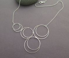 Sterling silver necklace for women, a unique and delicate bubble necklace with multiple spiraling circles. A beautiful, light, and airy circles necklace. The hand-forged spiraling circles are assembled to create a unique asymmetrical bubble necklace design.I make the spirals from a sterling silver wire, and give them a hammered finish to add texture and strength to the metal.I also make other versions of this necklace, you can see two more designs in the last photo. The links are available below Cat Necklace Silver, Asymmetrical Necklace, Circles Necklace, Silver Necklace For Women, Paw Print Necklace, Bubble Necklaces, Beachglass Jewelry, Sterling Silver Cat, Mixed Metal Jewelry