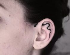 a close up of a person's ear with a small tattoo on the side