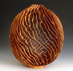 a wooden object with wavy lines on it's surface, in the shape of a ball