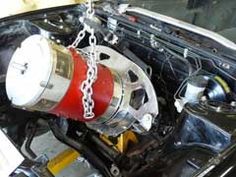 the engine compartment of a car with chains hanging from it