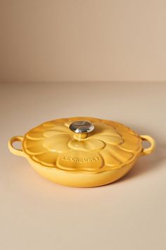 a yellow casserole dish sitting on top of a white countertop next to a brown wall