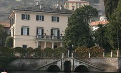 a large white house sitting on the side of a river