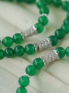 This elastic necklace combines traditional Chinese aesthetic elements with modern style. Featuring sparkling zirconia beads and soothing green agate beads, this necklace exudes elegance and sophistication. The intricate bead arrangement creates a harmonious balance between vintage charm and modern style. Metal: Recycled Sterling Silver Gemstone: Cubic Zirconia,Green Onyx Diameter: Long 760mm,Short 440mm Weight: Long 42g,Short 24g Elegant Beaded Necklaces With Round Beads For Meditation, Elegant Jade Beads As Gift, Elegant Round Beaded Necklaces For Meditation, Elegant Jade Beads For Jewelry Making, Elegant Jade Beaded Necklace With 8mm Beads, Elegant Jade Crystal Necklaces With Round Beads, Elegant Green Onyx Beaded Necklaces, Elegant Jade Gemstone Beads, Elegant Beaded Jade Crystal Necklaces