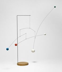 an abstract sculpture with balls and lines on it's sides, in front of a white background