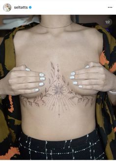 a woman's chest with her hands on the top of her stomach and an intricate design