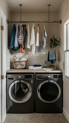 a washer and dryer in a small room with clothes hanging on the rack