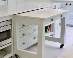 a white kitchen island with drawers underneath it