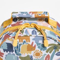 A backpack that's extra comfy and ready to handle all the adventures of the day. Decorated with colorful dino pals, a lush landscape and cheery yellow trim, this kids' small knapsack is constructed of supremely durable polyester fabric that includes recycled plastic bottles. A roomy interior holds everything your kid needs-books, school supplies, extra layers-and there's a padded pocket to keep their tablet protected. Outside pockets hold snacks, water bottles and more. Pair this book bag with t Dino Backpack, Kids Pencil Case, Books School, Lush Landscape, Back To School Bags, Backpack Gift, Yellow Trim, Toddler Backpack, Small Kids