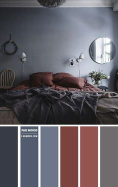 a bedroom with gray walls and red bedding in the center is an oval mirror