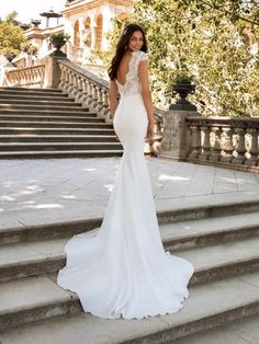 a woman in a wedding dress standing on some steps