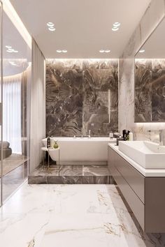 a large bathroom with marble walls and flooring, along with a bathtub in the middle