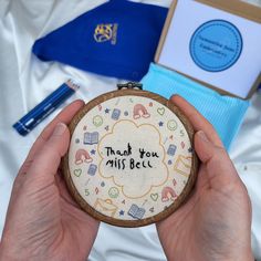 a person holding up a small embroidered badge with the words thank you miss belce on it