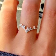 a close up of a person's hand with a diamond ring on their finger