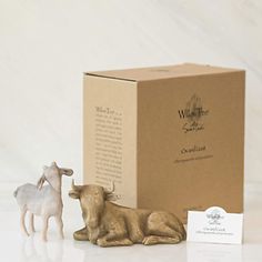 a cow and calf figurine sitting next to a box