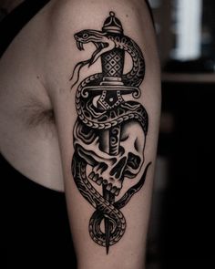 a woman's arm with a snake and dagger tattoo on it