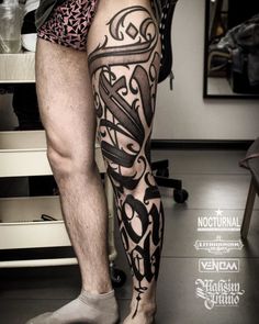 a man's legs with tattoos on them