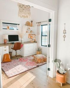 a living room filled with furniture and a rug on top of a hard wood floor