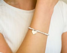 Fall in love all over again with this glimmering silver heart and pearl bracelet....................... White/ Ivory freshwater pearls are AA quality and measure about 2mm Shiny sterling heart measures about 13mm Chain is dainty 925 sterling silver Bracelet is adjustable (choose your size) Bracelet closes with a sterling silver spring clasp This is a handmade item and made for you after the order is placed PACKAGINGAll Jewelry is carefully packaged for a safe arrival and is secured in a jewelry Silver Spring, Sterling Silver Bracelet, Sterling Silver Heart, Silver Heart, Pearl Bracelet, Delicate Bracelet, Sterling Silver Bracelets, Fresh Water, Fall In Love