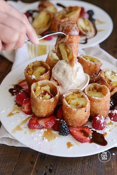 a person is scooping ice cream into some fruit pastries on a white plate